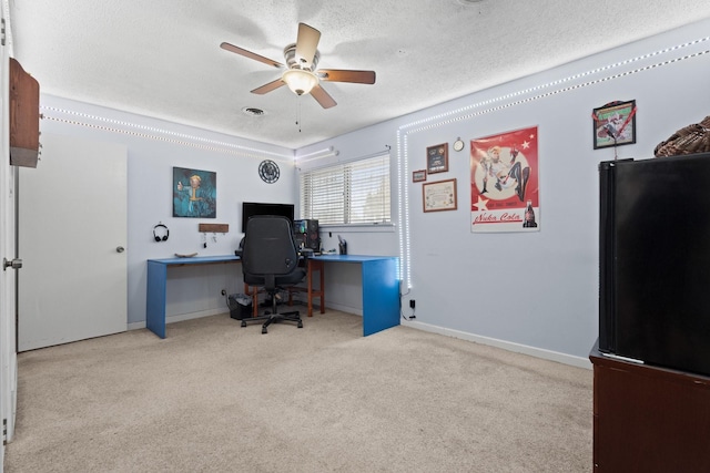 carpeted office space with a ceiling fan, a textured ceiling, and baseboards