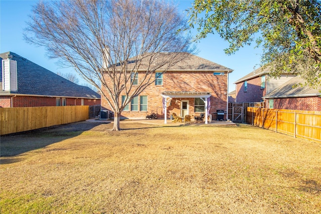 rear view of property featuring a patio, cooling unit, a yard, a fenced backyard, and brick siding