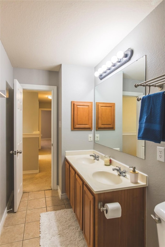 full bathroom featuring tile patterned flooring, double vanity, toilet, and a sink