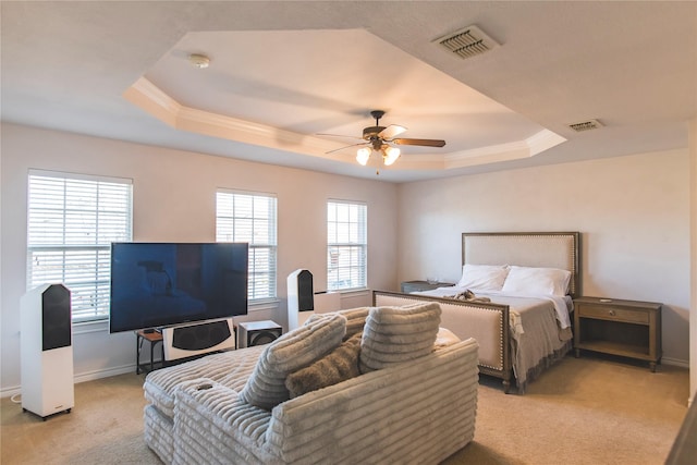 bedroom featuring light carpet, visible vents, and a tray ceiling