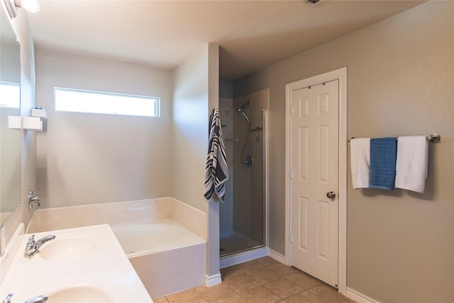 full bathroom with tile patterned flooring, a garden tub, a stall shower, and a sink