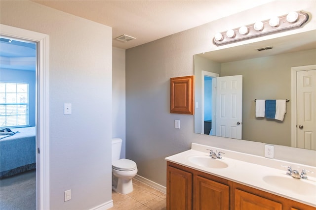 ensuite bathroom featuring tile patterned floors, visible vents, toilet, and a sink