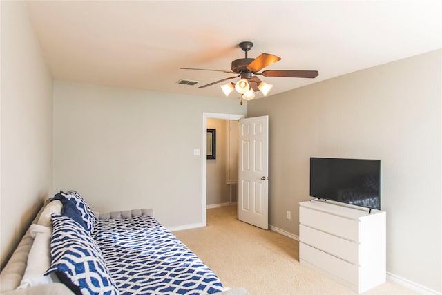 bedroom featuring visible vents, light colored carpet, a ceiling fan, and baseboards