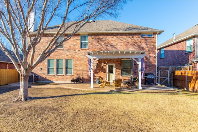 back of property with a lawn, a patio, a fenced backyard, roof with shingles, and brick siding