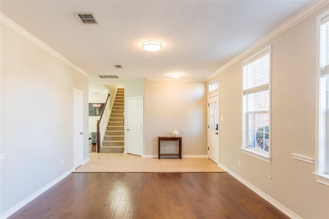 entrance foyer with crown molding, wood finished floors, visible vents, and baseboards