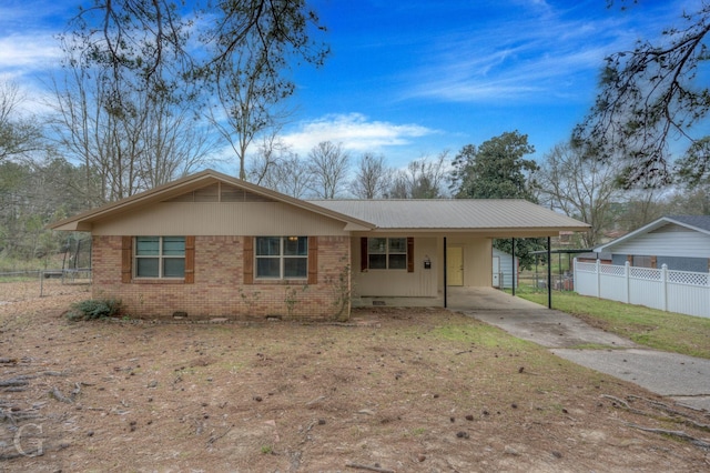 ranch-style home featuring brick siding, an attached carport, driveway, and fence