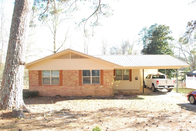 ranch-style house featuring a carport and brick siding