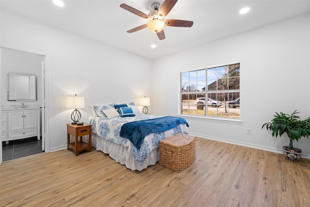 bedroom featuring baseboards, ensuite bathroom, wood finished floors, and recessed lighting