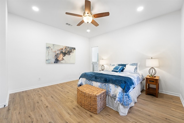 bedroom with wood finished floors, visible vents, and baseboards