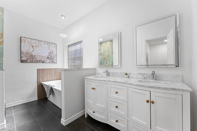 bathroom with a freestanding bath, double vanity, a sink, and tile patterned floors