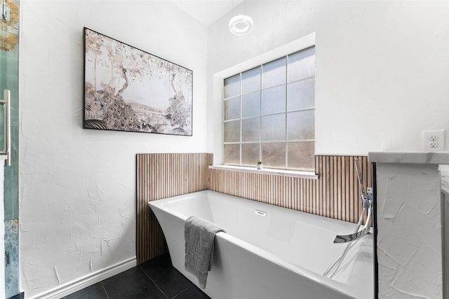 bathroom with a freestanding tub and tile patterned floors