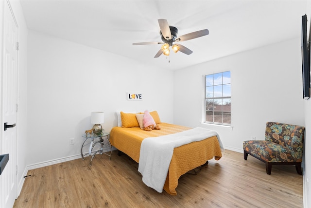 bedroom with light wood-style flooring, baseboards, and ceiling fan