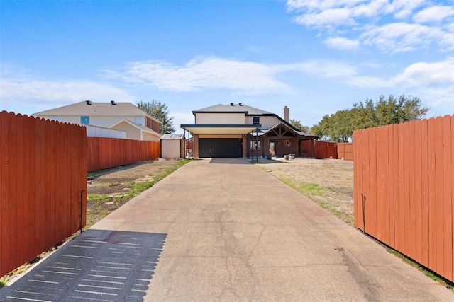 view of front of home featuring a garage, driveway, and fence