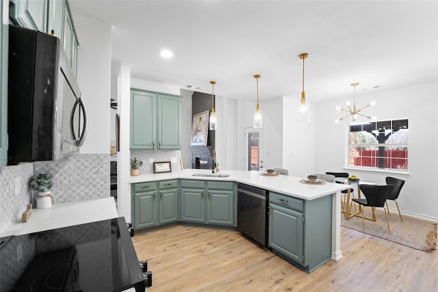 kitchen with a peninsula, a sink, light countertops, dishwasher, and light wood finished floors