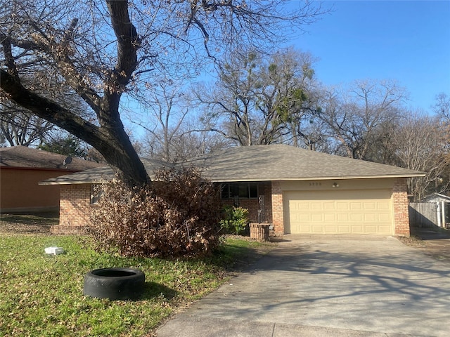 view of front of property featuring an attached garage, driveway, and brick siding