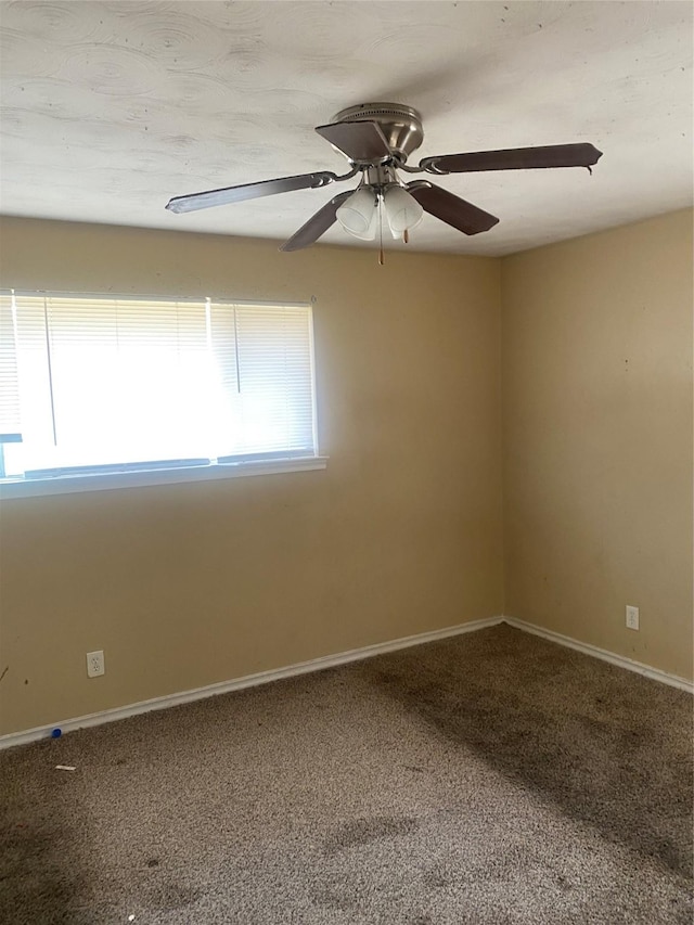 unfurnished room featuring carpet flooring, ceiling fan, and baseboards