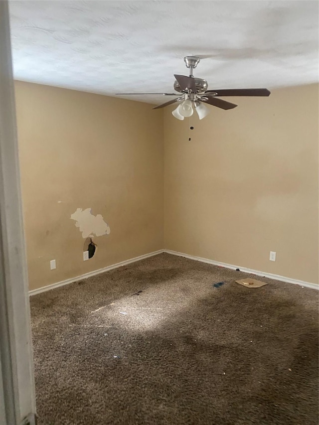 empty room with carpet floors, a ceiling fan, and baseboards