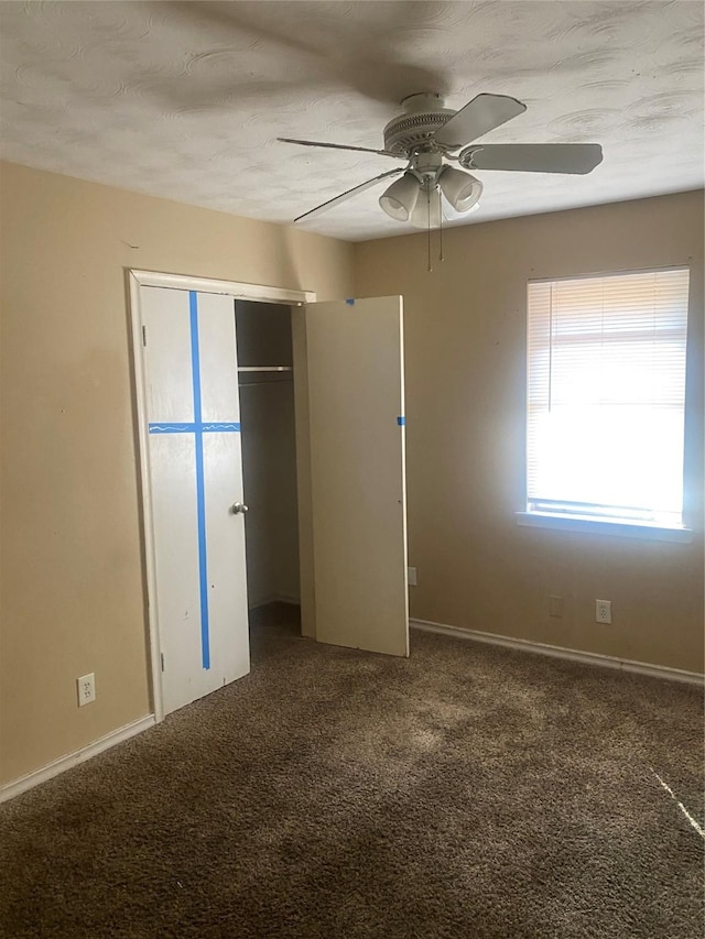 unfurnished bedroom with a ceiling fan, carpet, a closet, and baseboards