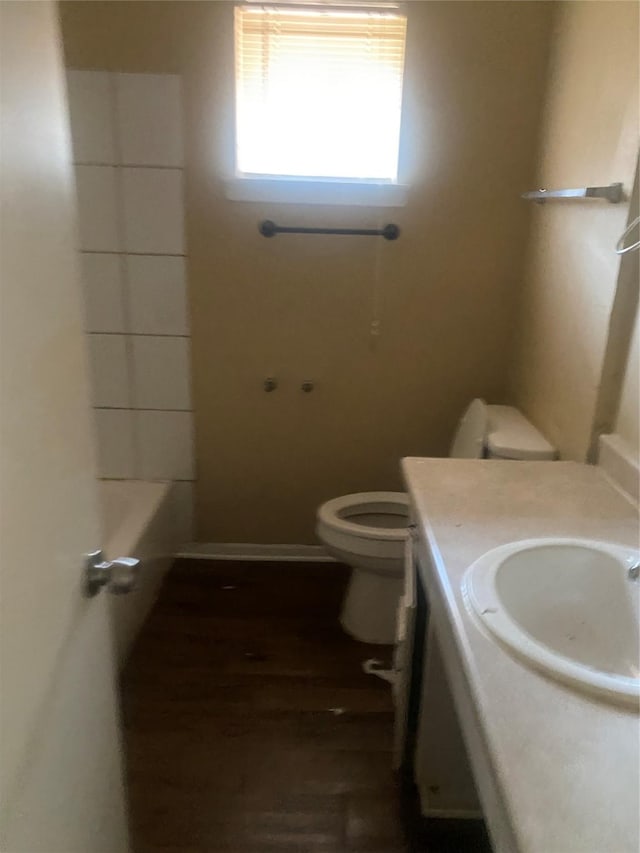 bathroom featuring toilet, wood finished floors, vanity, a shower, and a bathtub