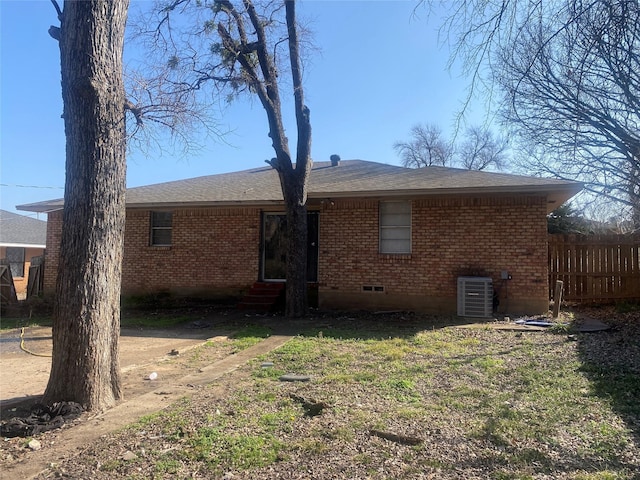 back of property with entry steps, brick siding, fence, and central AC unit