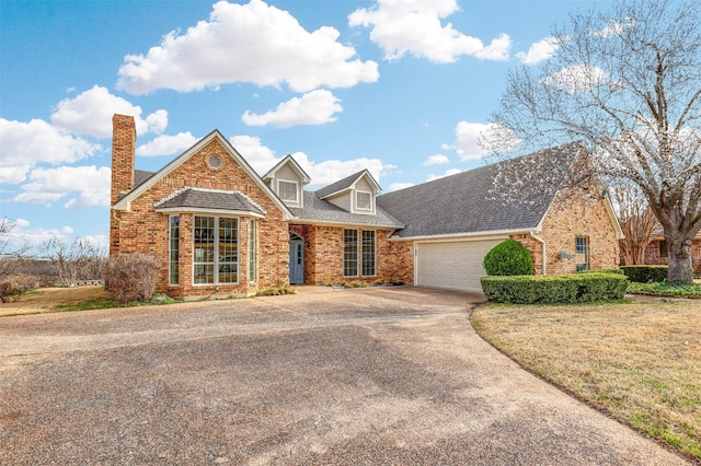 view of front of home featuring a garage, driveway, brick siding, and roof with shingles