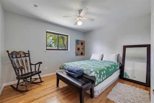 bedroom with light wood-style floors, ceiling fan, and baseboards