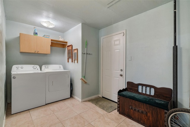 laundry area with cabinet space, baseboards, light tile patterned flooring, and independent washer and dryer