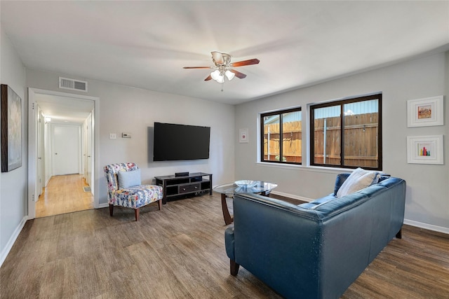 living room with baseboards, ceiling fan, visible vents, and wood finished floors