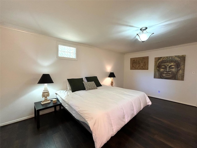 bedroom with ornamental molding, wood finished floors, and baseboards