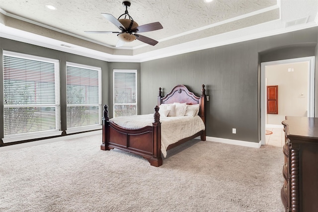 bedroom featuring light carpet, visible vents, a raised ceiling, crown molding, and a textured ceiling