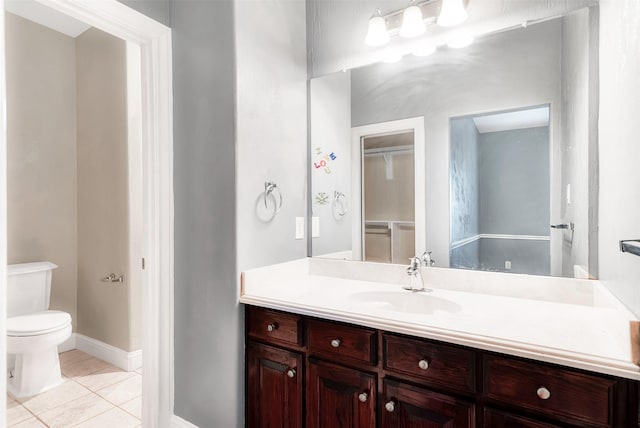 bathroom with baseboards, vanity, toilet, and tile patterned floors