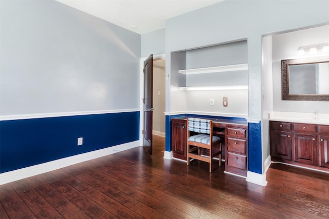 unfurnished office with baseboards and dark wood-style flooring