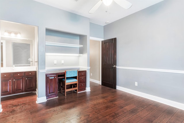 unfurnished office featuring dark wood-style floors, baseboards, and a ceiling fan