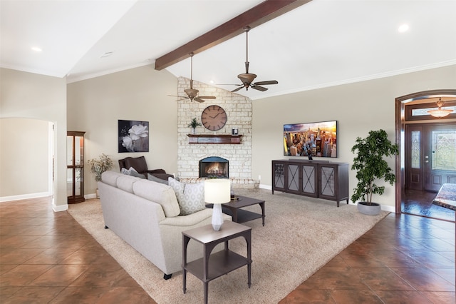 living area with ornamental molding, beamed ceiling, a fireplace, and baseboards