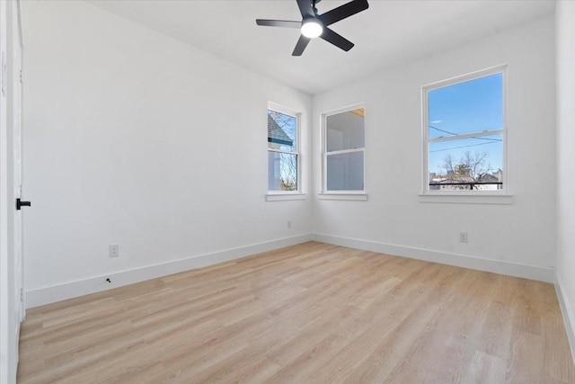 unfurnished room featuring light wood-style floors, plenty of natural light, and baseboards