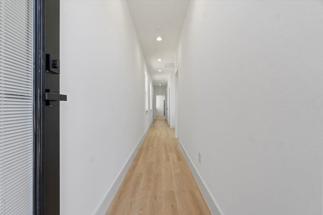 corridor featuring light wood-type flooring, attic access, baseboards, and recessed lighting