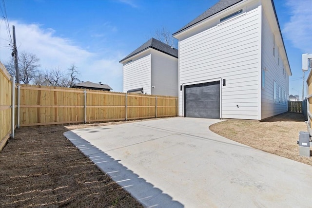 view of side of property with a fenced backyard and concrete driveway