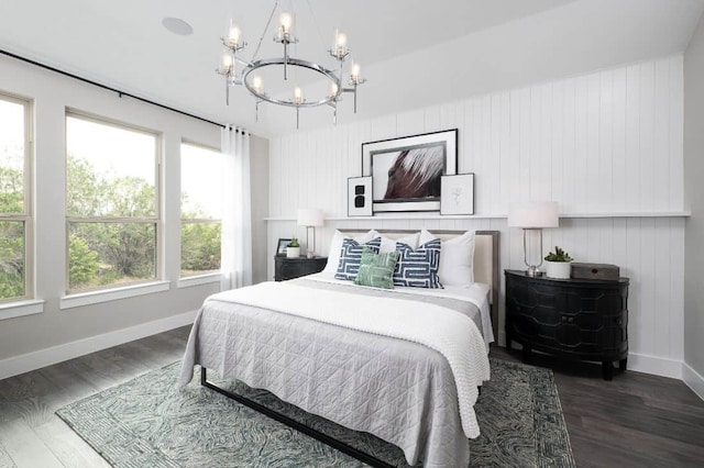 bedroom featuring baseboards, a chandelier, and wood finished floors