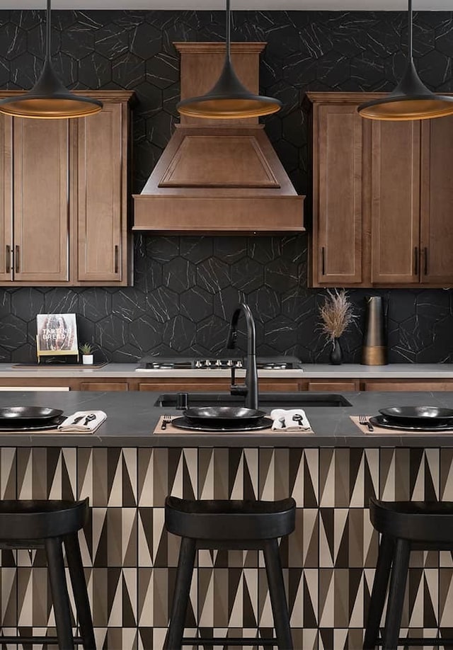 kitchen featuring custom range hood, pendant lighting, and decorative backsplash