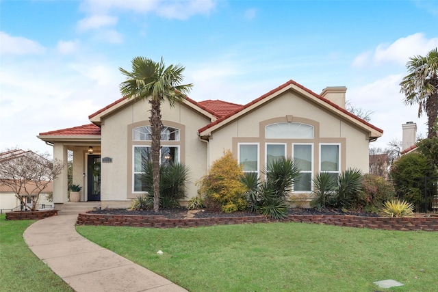 mediterranean / spanish-style house with a front lawn, a tile roof, and stucco siding