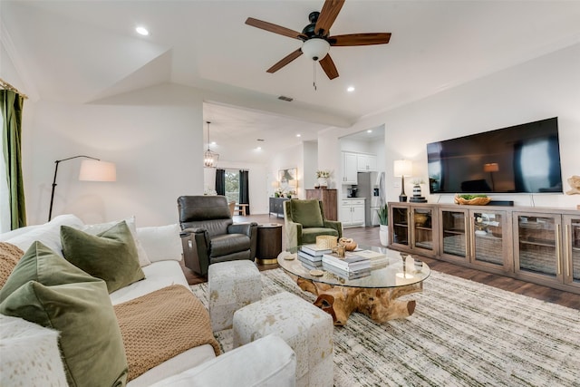 living area featuring recessed lighting, visible vents, vaulted ceiling, wood finished floors, and ceiling fan with notable chandelier