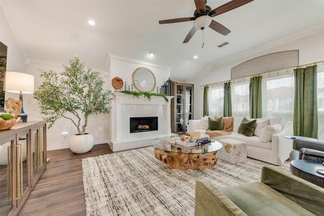 living room featuring ornamental molding, a premium fireplace, wood finished floors, and visible vents