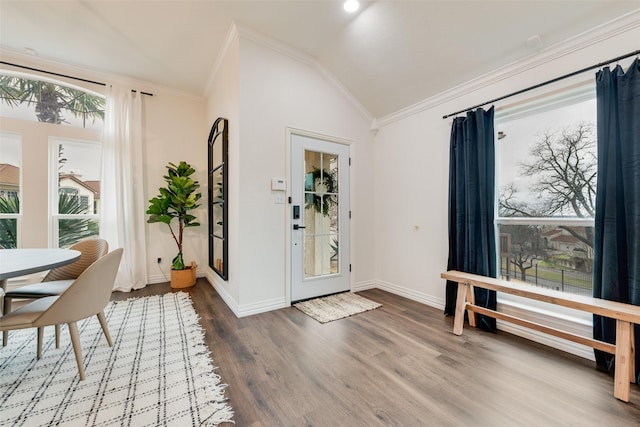 entryway with ornamental molding, lofted ceiling, baseboards, and wood finished floors