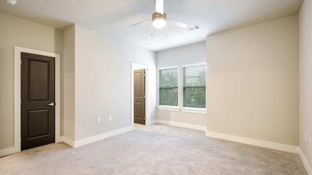 unfurnished bedroom featuring a ceiling fan, visible vents, light carpet, and baseboards