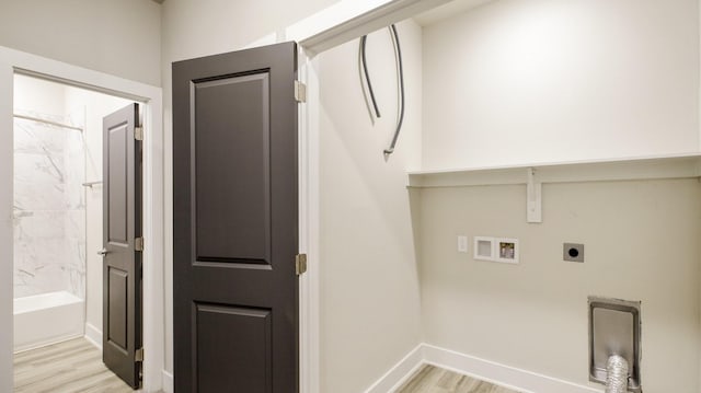 clothes washing area featuring laundry area, baseboards, hookup for a washing machine, hookup for an electric dryer, and light wood-type flooring