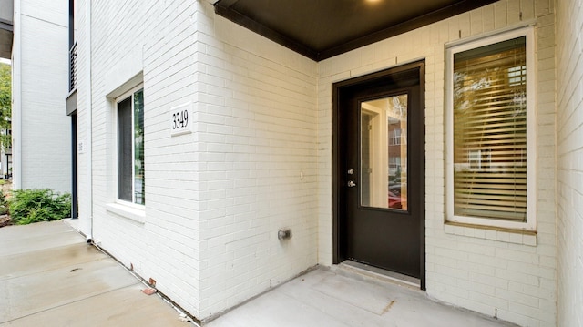 view of exterior entry featuring brick siding