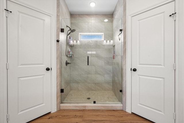 full bath featuring a stall shower and wood finished floors