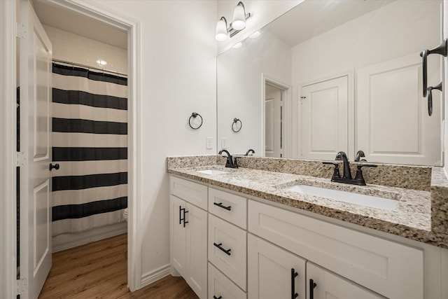 2301 Camryn Ln, Mabank, TX 75147 - bathroom featuring wood finished floors, double vanity, baseboards, and a shower with curtain