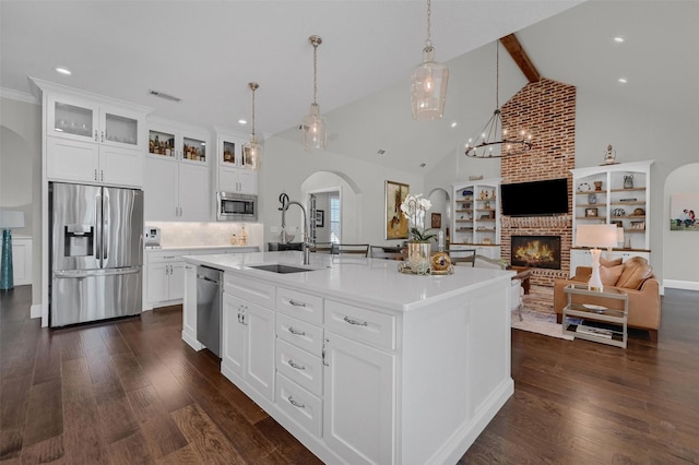 kitchen featuring a sink, dark wood finished floors, arched walkways, and stainless steel appliances