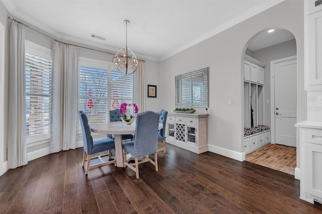 dining area featuring arched walkways, visible vents, dark wood-style flooring, and ornamental molding